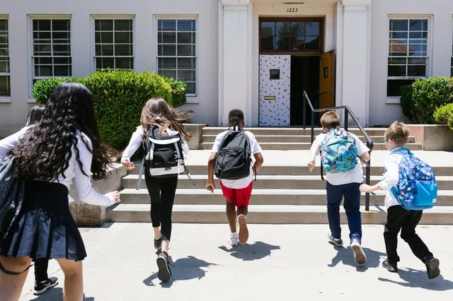 school children running to school entrance